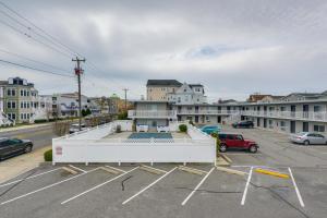 un grand bâtiment blanc dans un parking dans l'établissement Ocean City Condo with Pool Walk to Boardwalk!, à Ocean City