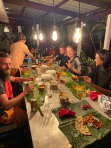 a group of people sitting around a table eating food at Bellevue Tamarin in Tamarin