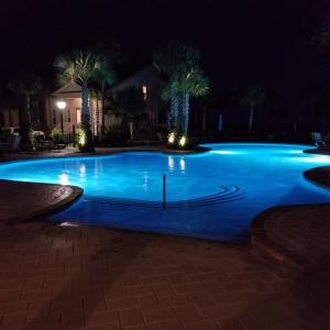 a swimming pool at night with blue lighting at HONU KAI - 3 Bedroom Townhouse townhouse in Jekyll Island