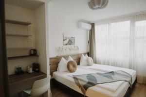 ザルツブルクにあるパークホテル ブルナウアーのベッドルーム(白いベッド1台、窓付)
