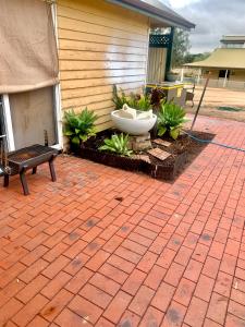 a brick patio with a large bowl on the side of a house at cottage of character in Sunbury