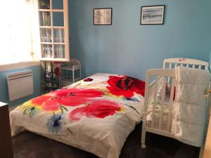 1 dormitorio con 1 cama con manta de flores en Maison St Florent en Saint-Florent-le-Jeune