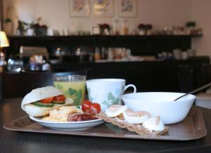 ein Tablett mit Essen, einem Sandwich und einer Tasse Kaffee in der Unterkunft Hotell Drott in Norrköping