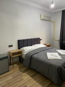 1 dormitorio con 1 cama grande y TV en BADU BOUTİQUE HOTEL en Karşıyaka