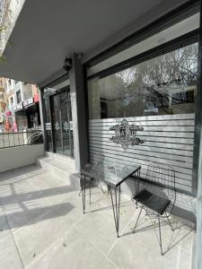 two chairs and a table in front of a store window at BADU BOUTİQUE HOTEL in Karşıyaka