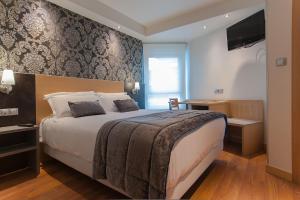 a hotel room with a large bed and a television at Sercotel Codina in San Sebastián