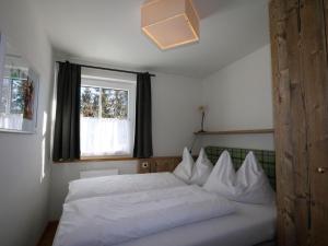 a white bed in a bedroom with a window at Holiday house, Flachau in Flachau