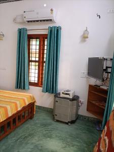 a bedroom with a bed and a television in it at Kadalamma Beach Homestay in Alleppey