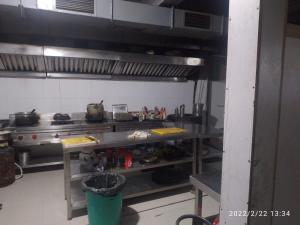 a kitchen with a stove and a table in it at Hotel Rivasa Regency in New Delhi