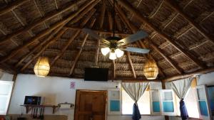 a ceiling fan and lights in a room at Casa Frida in Chelem