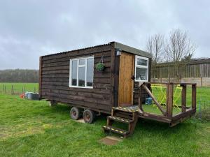 a tiny house on a trailer in a field at Bothy hut in Tring