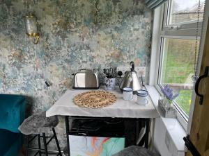 Bothy hut في ترينج: مطبخ مع طاولة عليها فطيرة