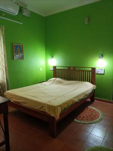 a green bedroom with a large bed in a room at Kadalamma Beach Homestay in Alleppey