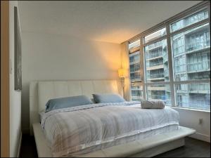 a bedroom with a large bed with a large window at 1200+sqft Luxury Corner Suite in Toronto