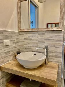 a bathroom with a white bowl sink on a wooden counter at Cà Lea,2 Minuti dalla Spiaggia di Monterosso in Monterosso al Mare
