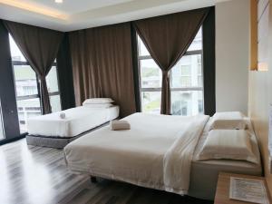 two beds in a hotel room with large windows at TOWERMAS HOTEL in Sibu