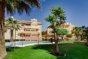 un grande condominio con piscina e palme di La Alcazaba de Cristina a El Puerto de Santa María