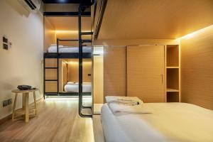 a bedroom with two bunk beds and a table at Phra Nakhon Poshtel in Bangkok