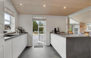 a kitchen with white cabinets and a large counter top at Nice Home In Tarm With Sauna in Tarm