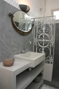 ein Bad mit einem Waschbecken und einem Spiegel in der Unterkunft Chambres d'hôtes Christa in Saint-Pair-sur-Mer