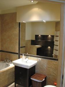 a bathroom with a sink and a tub and a mirror at Apartament w Ustroniu in Ustroń