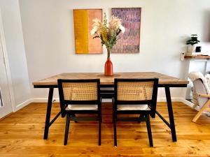 uma mesa de jantar com duas cadeiras e um vaso com flores em Walnut House Mildura em Mildura
