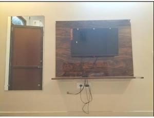 una TV a schermo piatto seduta su una mensola in camera di Hotel Moody Moon, Bareilly a Bareilly