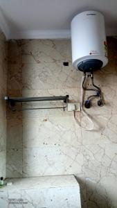 a lamp on the corner of a bathroom with a marble wall at Hotel Rivasa Regency in New Delhi +19 photos