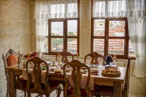 a dining room with a table with food on it at Yeşil Konak Cave Hotel in Ürgüp