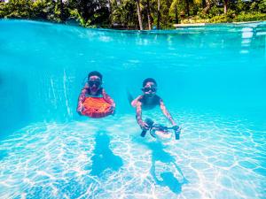 dos personas en el agua en el océano en Novotel Phuket Kata Avista Resort and Spa, en Kata Beach