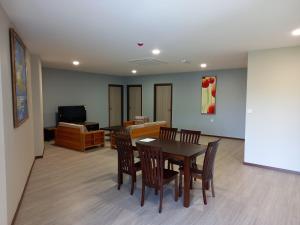 a dining room with a table and chairs and a television at KAN JIA in Miri