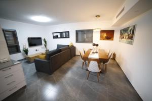 una sala de estar con un sofá y una mesa en חופשה בטבריה בבית ענק ל 8 אנשים גדול וחדש, en Tiberíades