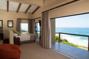 a bedroom with a bed and a view of the ocean at Dolphins on Six Self Catering Apartments in Wilderness