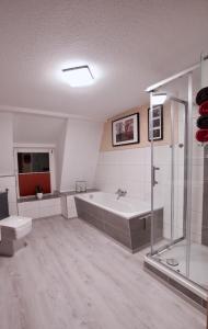 a large bathroom with a tub and a shower at Ferienwohnung Ostard 2 in Thale