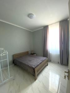- une chambre avec un lit et une fenêtre dans l'établissement Cozy House Tbilisi, à Tbilissi
