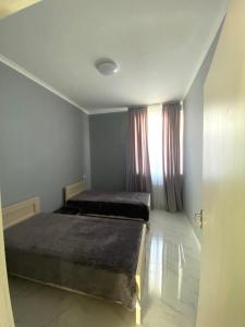 - une chambre avec 2 lits et une fenêtre dans l'établissement Cozy House Tbilisi, à Tbilissi