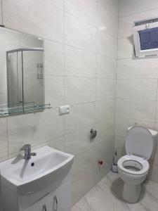 La salle de bains blanche est pourvue de toilettes et d'un lavabo. dans l'établissement Cozy House Tbilisi, à Tbilissi