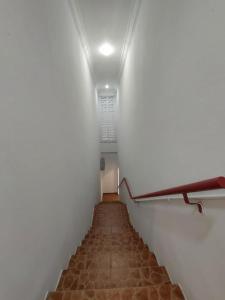 a long staircase with a white wall and a whiteboard at Warisan Family inn @ Seafront in Semporna