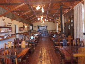 an empty dining room with wooden tables and chairs at The Grey's Inn in Machadodorp