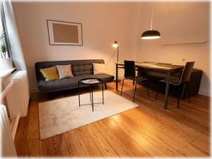 a living room with a couch and a table at Gemütlich - 2 Zimmer-Altbau, 24h Check-in in Kiel +8 photos