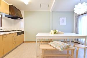 a kitchen with a white table and some chairs at ID STAY Haneda 2 in Tokyo