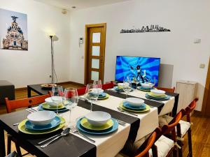 a dining room with a table with chairs and a television at La Latina Premium Home in Madrid