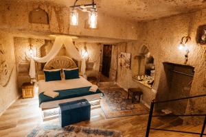 1 dormitorio con 1 cama y chimenea en una habitación en Bayar Cave Suites, en Ürgüp