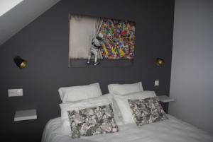 a bedroom with a bed with a painting on the wall at Au Temps Retrouvé in Nouans-les-Fontaines