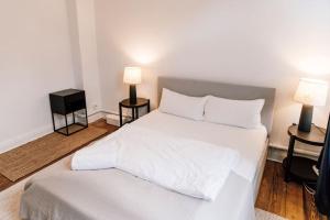 a white bed in a room with two lamps at Zentral und frisch eingerichtet: 2 Zi. 24h Checkin in Kiel