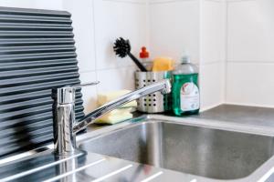 a kitchen sink with a faucet on a counter at Zentral und frisch eingerichtet: 2 Zi. 24h Checkin in Kiel