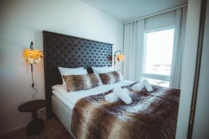 a bedroom with a large bed with a large window at Apukka Rovaniemi City Apartments in Rovaniemi