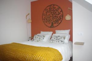 a bedroom with a bed with a tree picture on the wall at Au Temps Retrouvé in Nouans-les-Fontaines