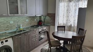 uma cozinha com uma mesa, um lavatório, uma mesa e cadeiras em BestBish apartment in the center em Bishkek