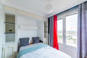 ein Schlafzimmer mit einem Bett und einem großen Fenster in der Unterkunft Le 4 Richet - Proche Disneyland Paris in Neuilly-sur-Marne